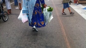 A shopper gets her produce at the City Heights Farmers' Market on an overcast Saturday morning.