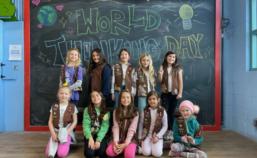 Photographs of kids smiling in front of a chalkboard that says "World Thinking Day"