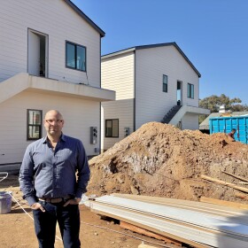 Daniel Shkolnik stands in front of a 12-unit ADU project his company is building in San Diego's Palm City neighborhood, Feb. 26, 2025.