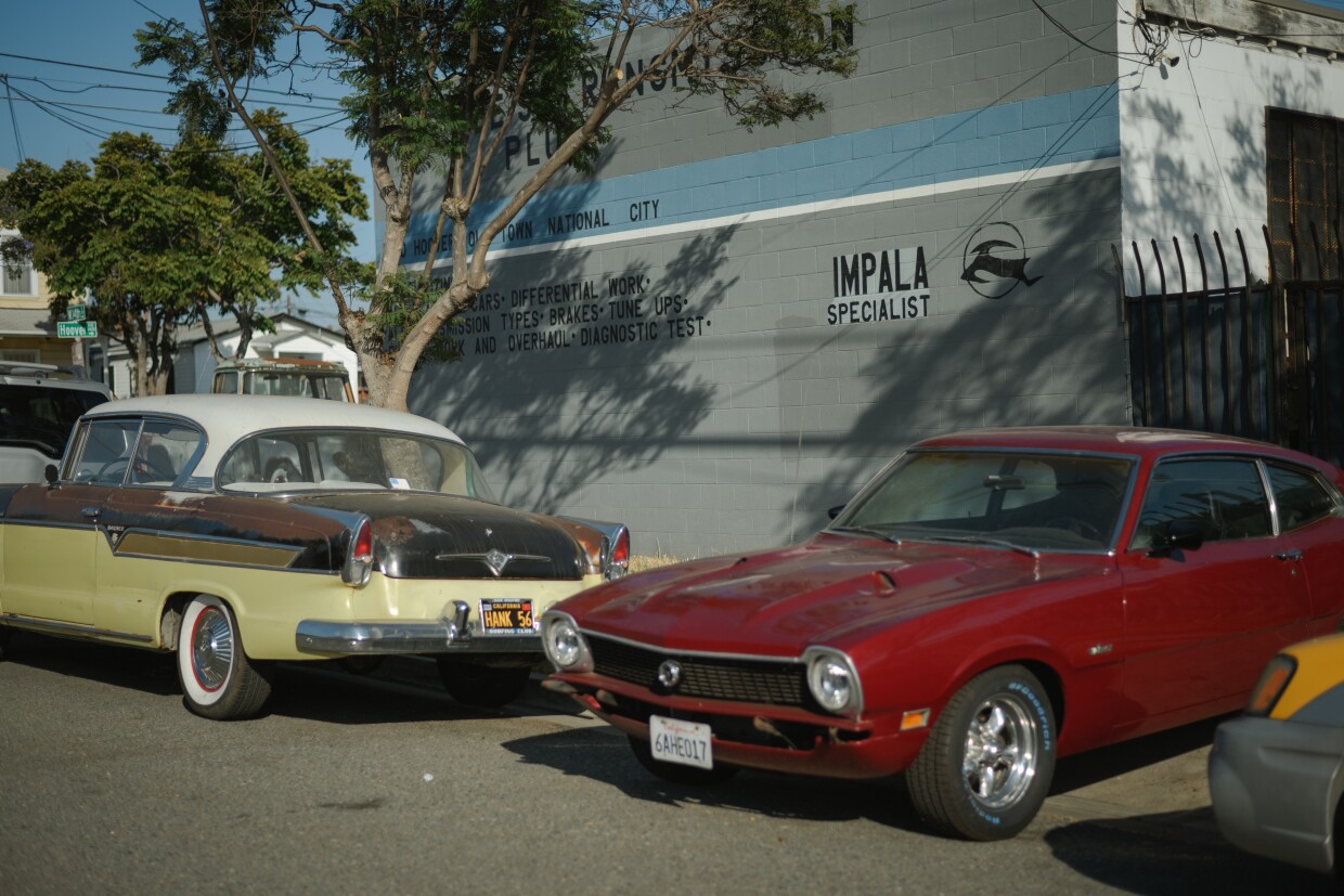 An auto body shop that serves antique cars sits next to residential homes in the Old Town neighborhood of National City, California on June 27, 2025.