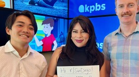 KPBS reporters (from left to right) Kori Suzuki, Tania Thorne and Andrew Bowen pose with an AMA sign on Oct. 9, 2024. 