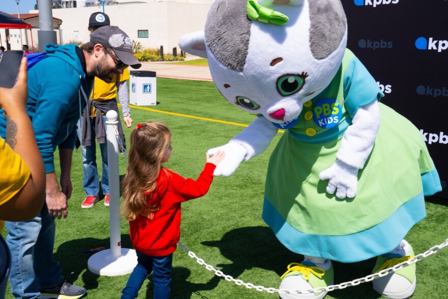 A parent and child meet Katerina Kittycat at Be My Neighbor Day across the street from the KPBS station on Saturday, April 6 in San Diego, CA.